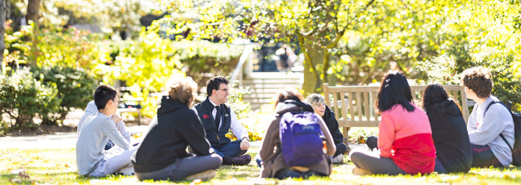 Head of School Chris Kolovos sits outside with BUA students