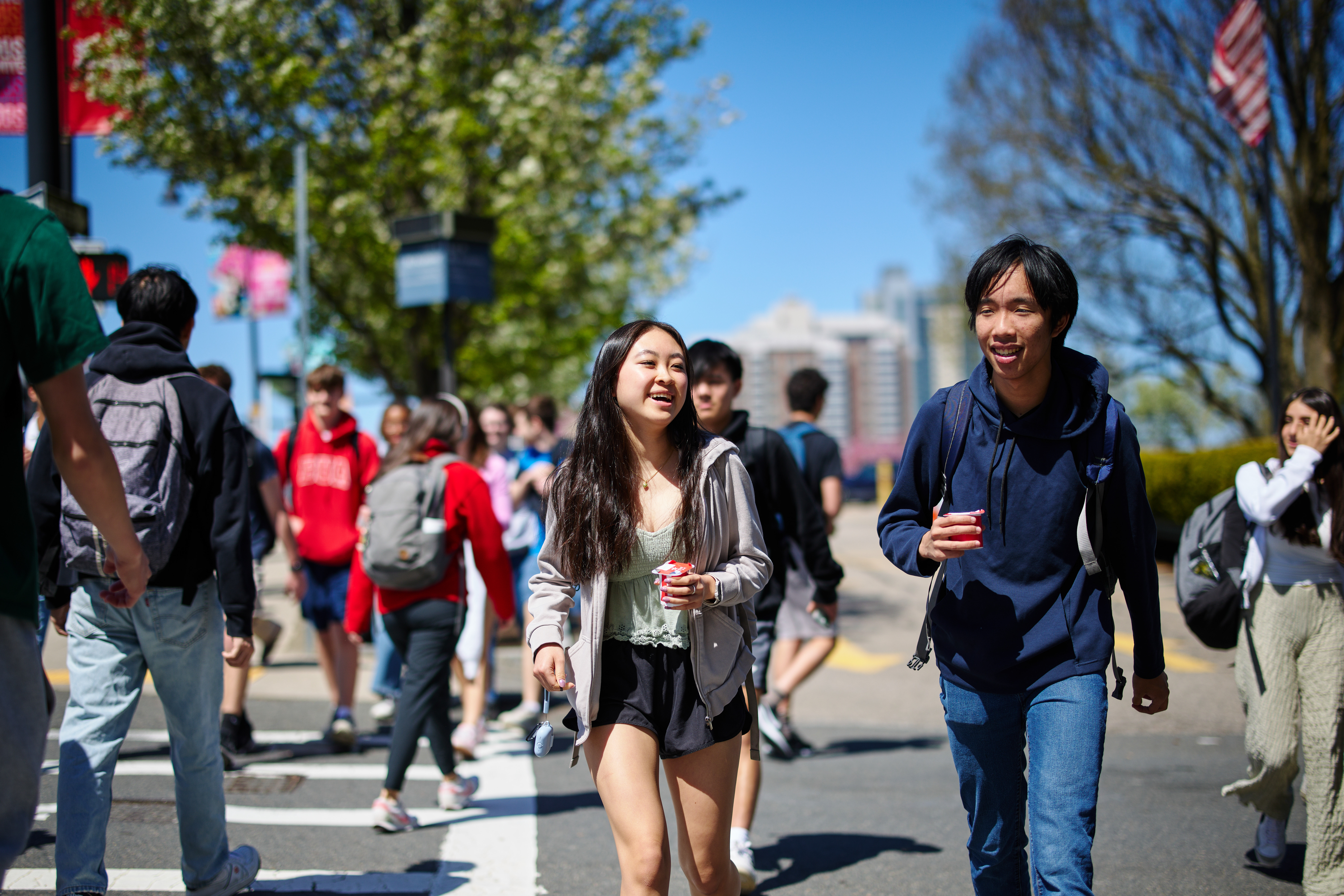 Two students walking across a crosswalk near Boston University Academy