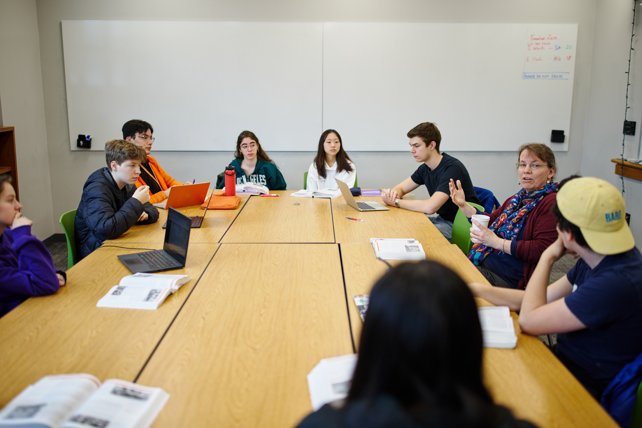 students sitting around a table with a teacher discussing history in a classroom at BUA