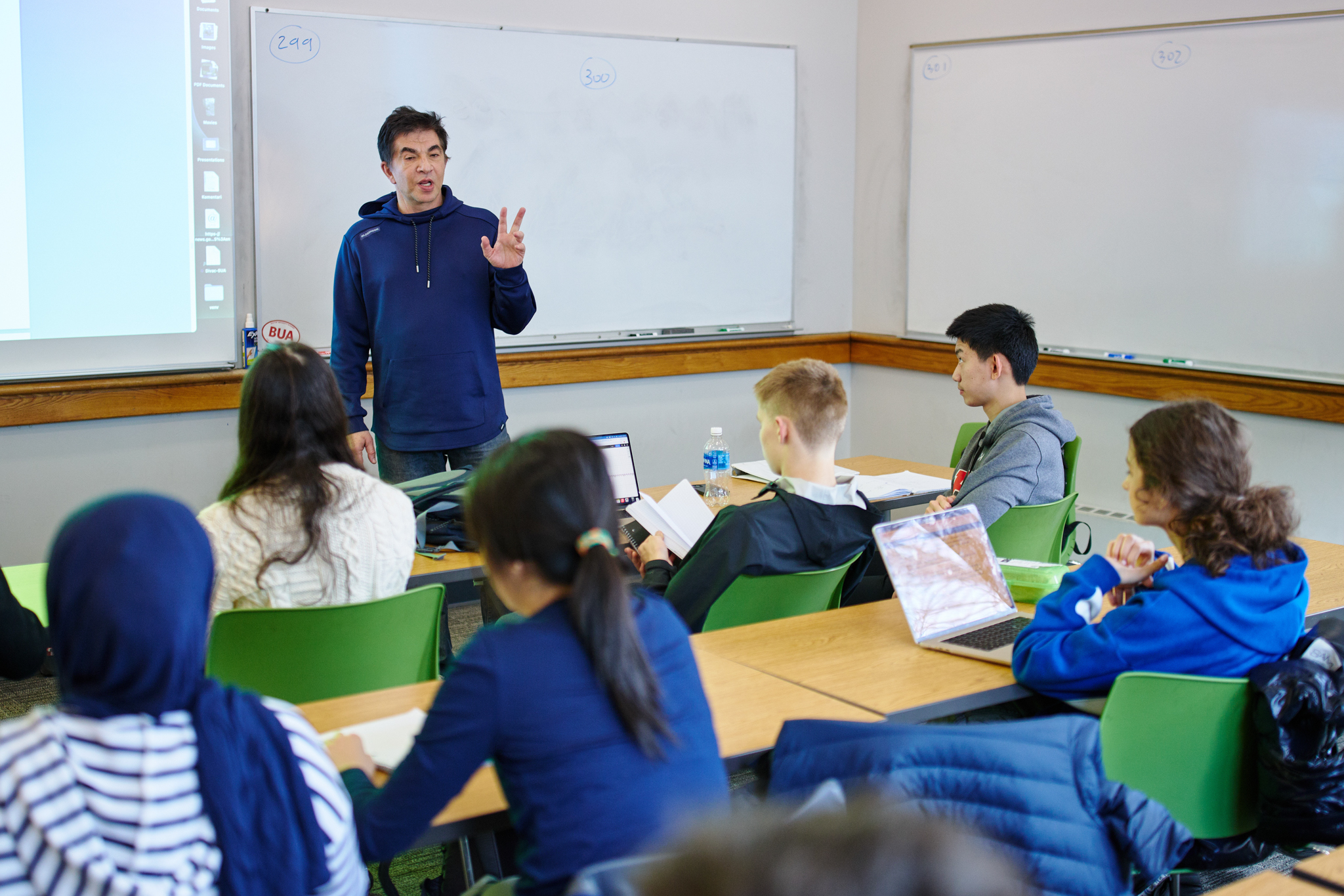 A teacher in a high school classroom teaching math to a group of students
